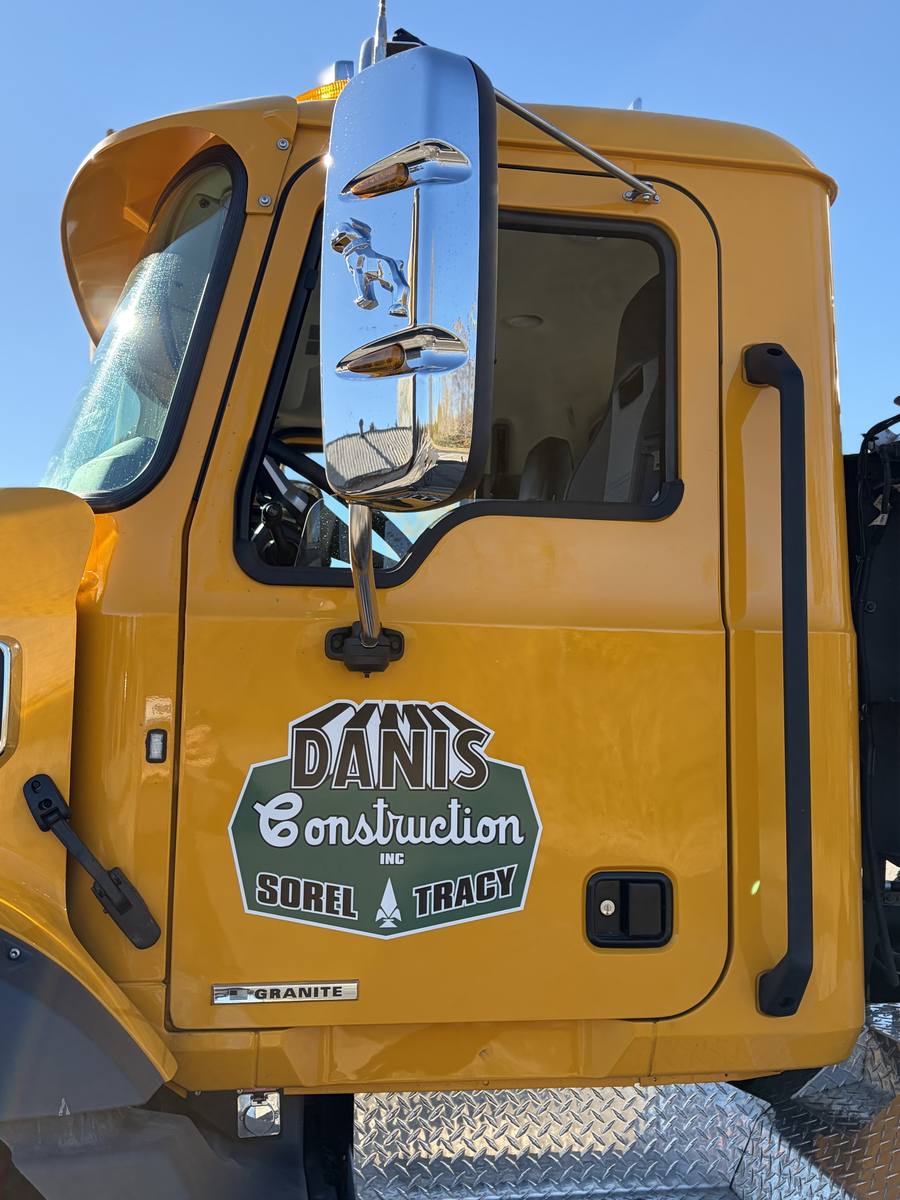 Logo Danis Construction Sorel-Tracy sur la portière d'un camion jaune